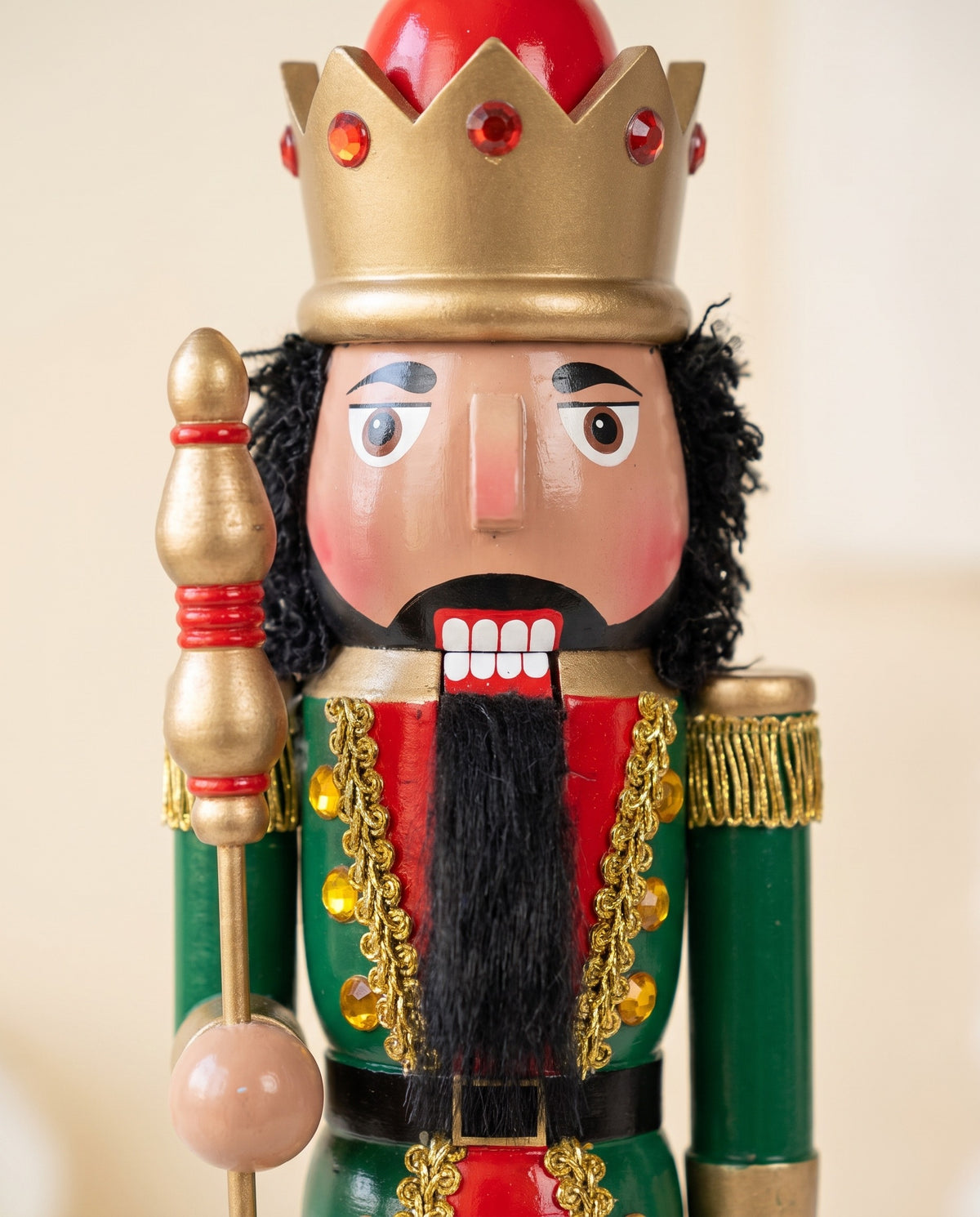 Close-up of the Maple King nutcracker's face with brown skin, curly hair and full beard